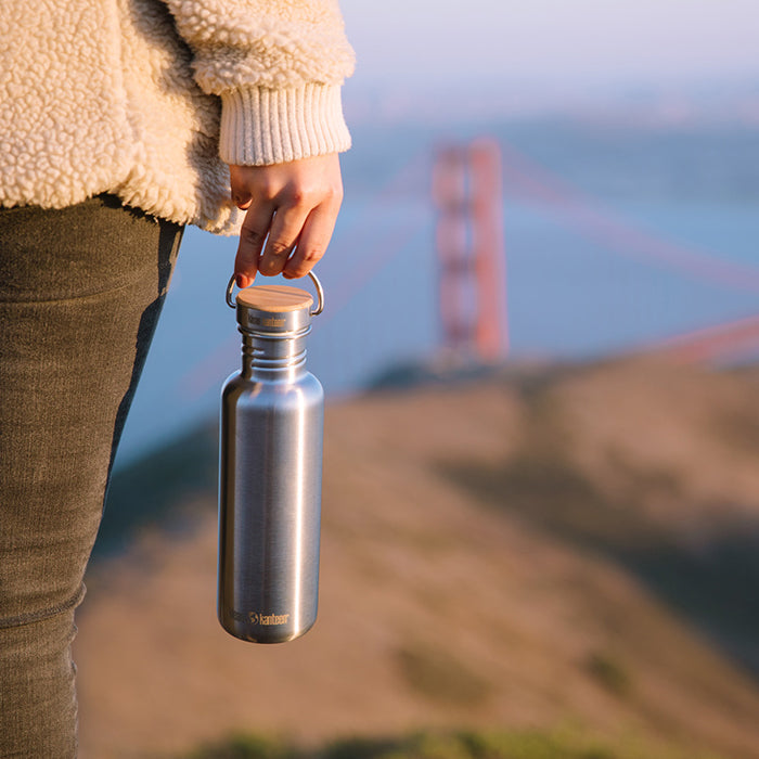 27oz-reflect-with-bamboo-cap-o9 K27SSLRF-BS-BAMBOO_reflect_bottle_bridge_lifestyle.jpg